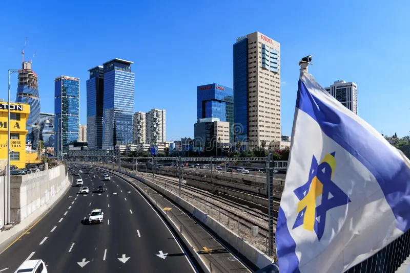 Israeli flag waving in front of Tel Aviv’s bustling modern highway and skyscrapers – a symbol of Israel’s dynamic economy and technological innovation.